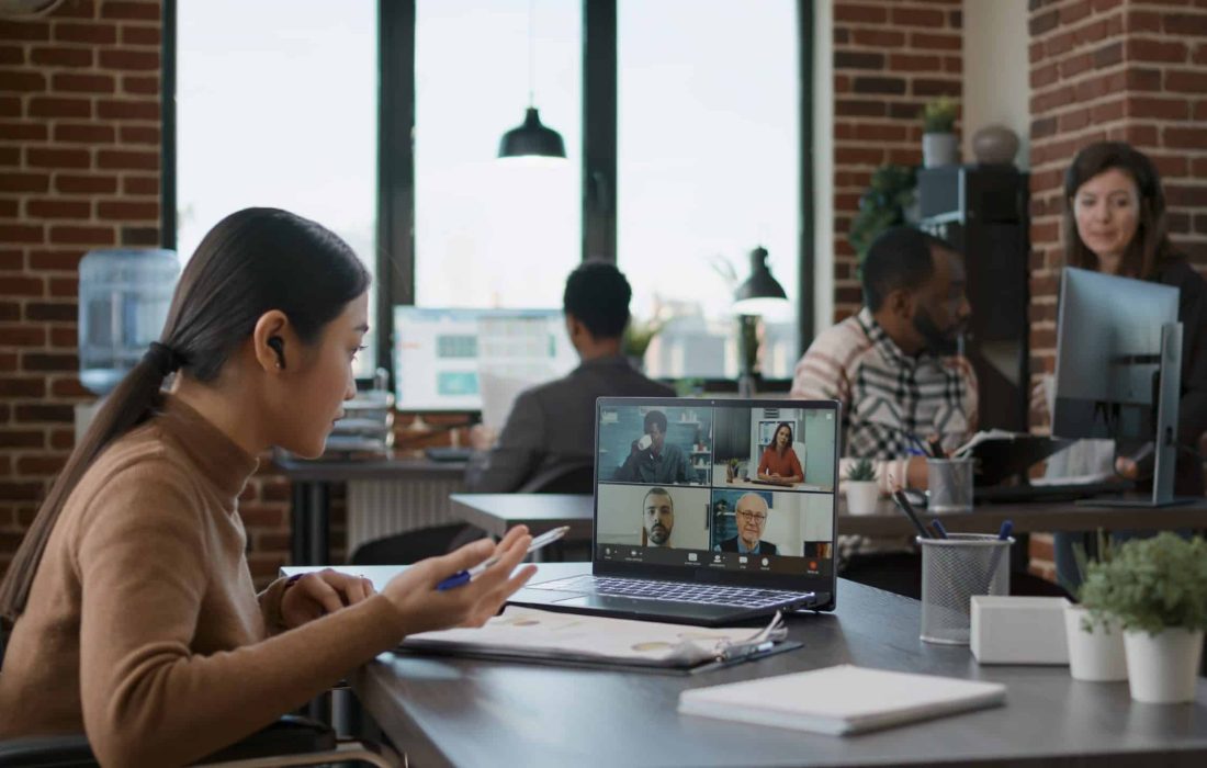 Diverse team of people meeting with woman on videocall communication, talking about startup business. Female employee with disability using online videoconference for remote conversation.