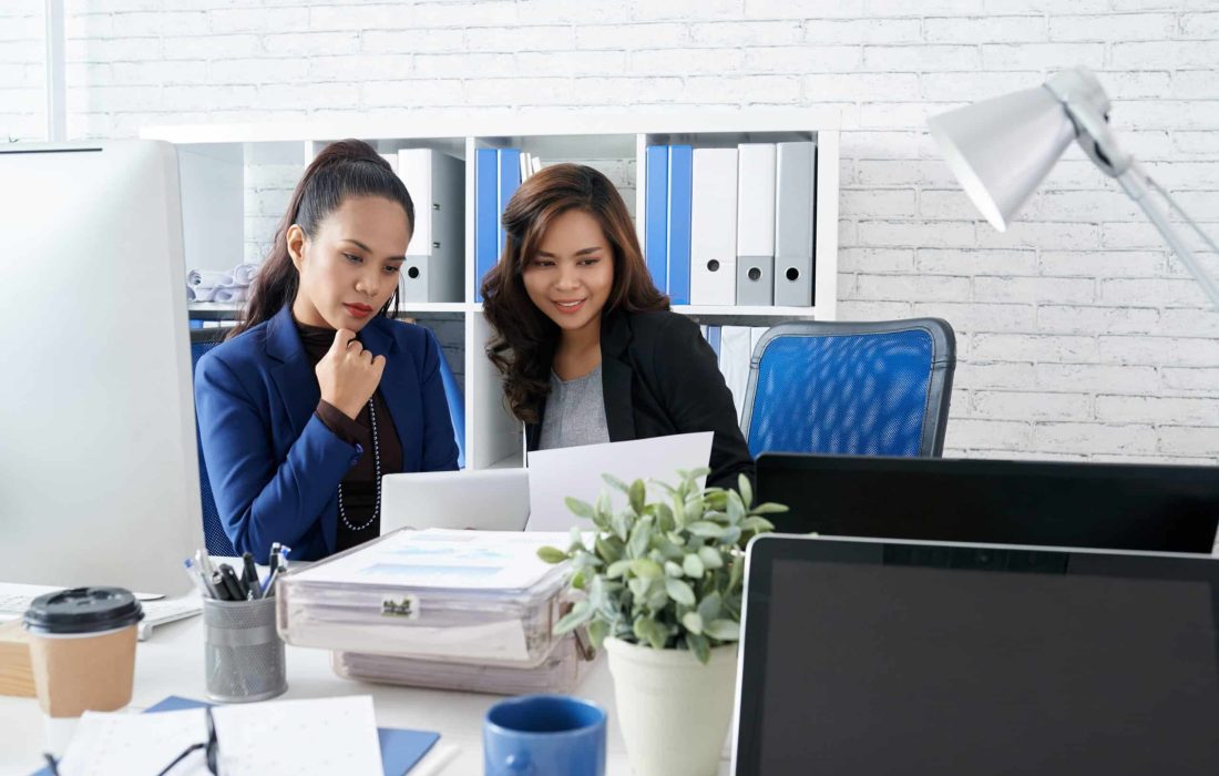 Filipino female coworkers working on project together